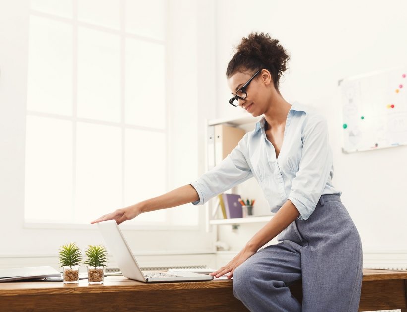 African-american businesswoman in modern office. Female worker opening laptop at office, copy space